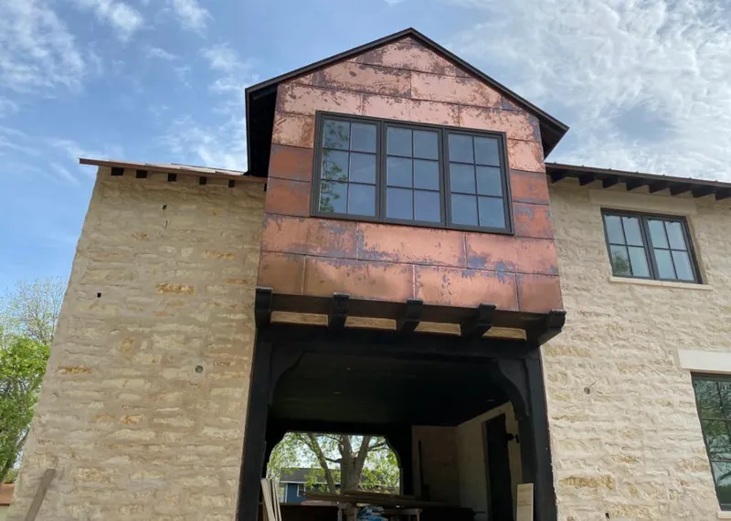 Copper metal panel facade on a stone building for Skylight Installation in Clarinda